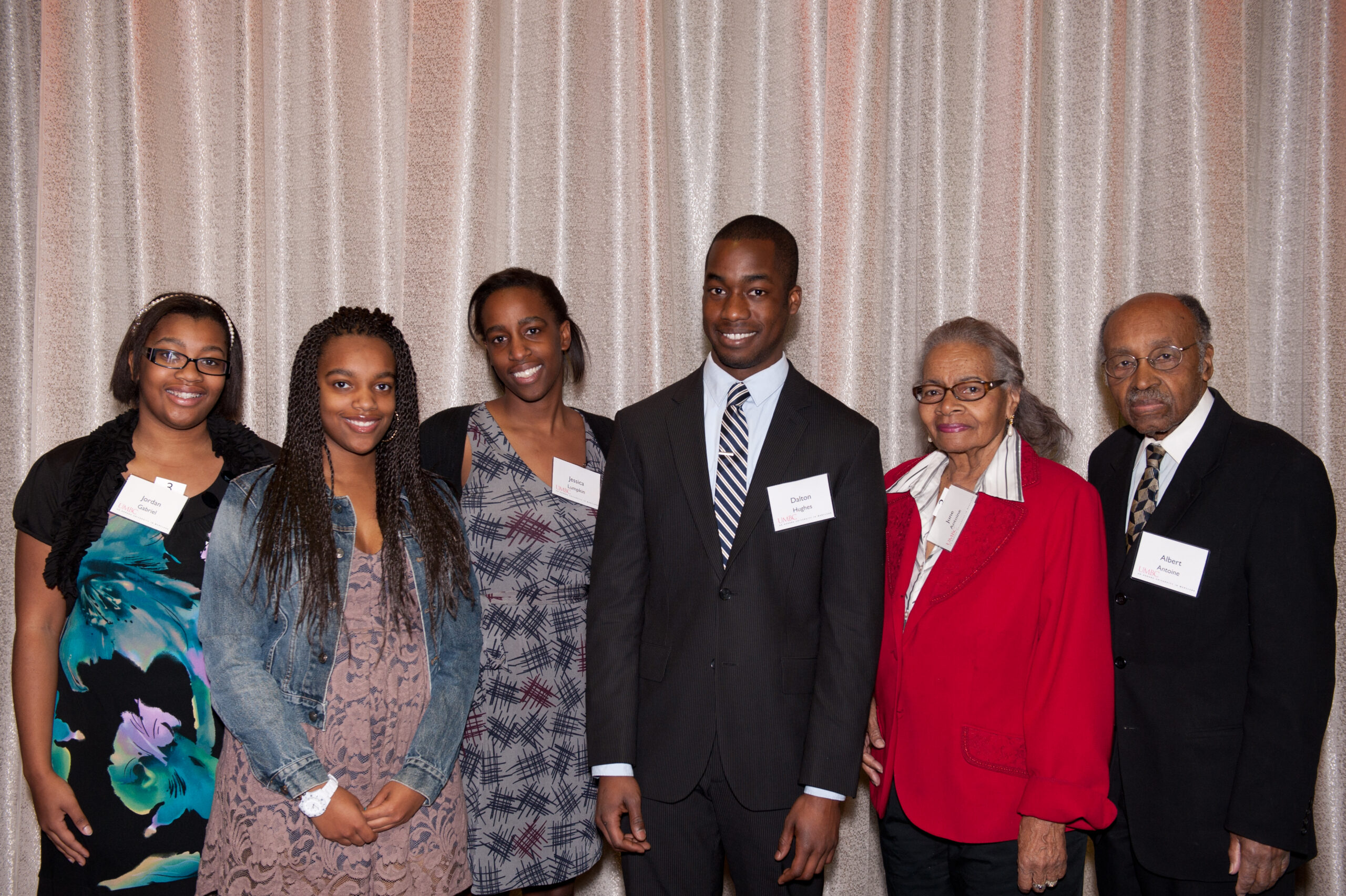 Family with nametags pose for picture at scholar luncheon