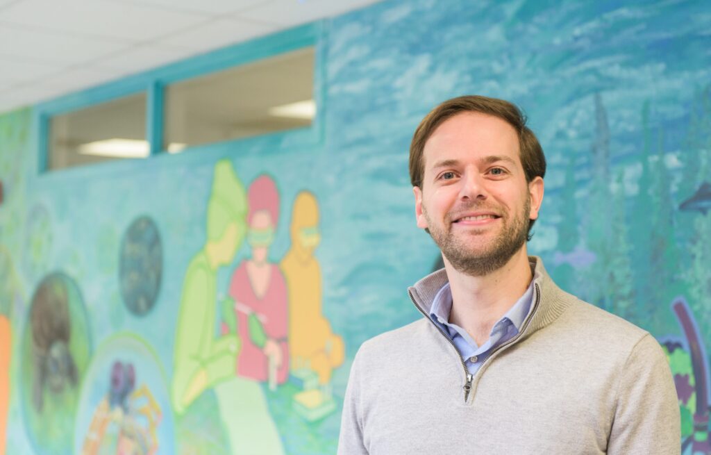 Man standing in front of biology mural