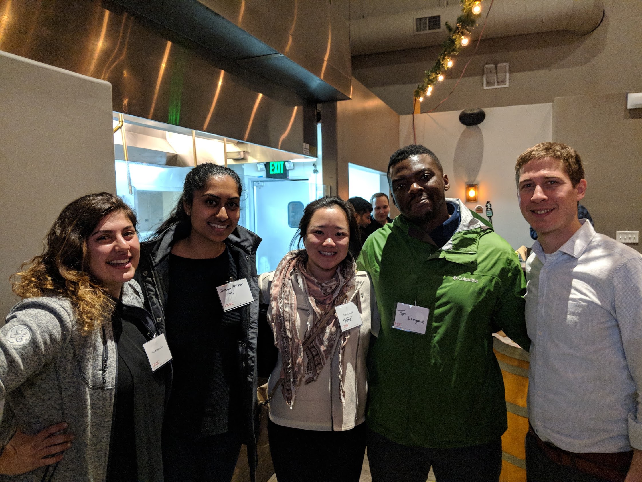 Bay area alumni pose together with name tags