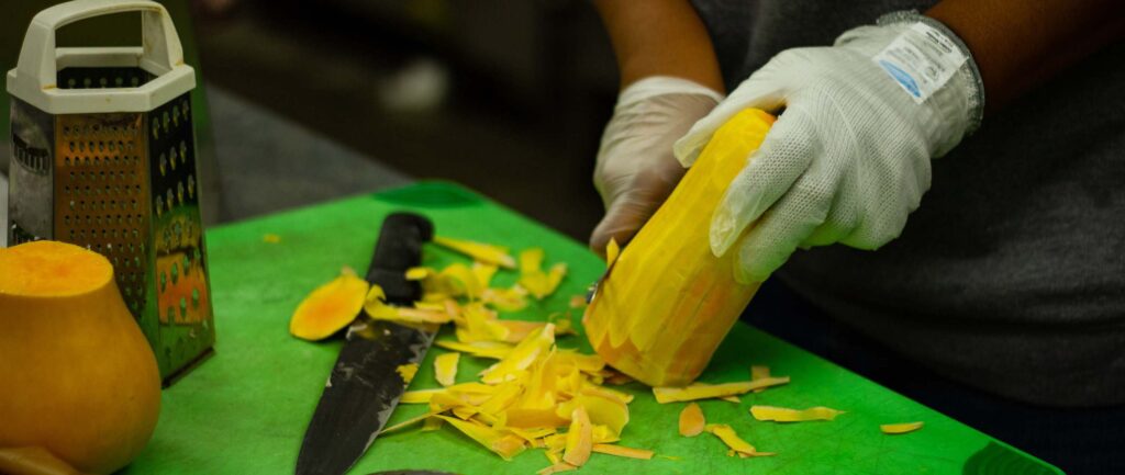 CHEW-MBC students chop veggies for their meal.