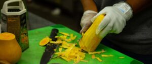 CHEW-MBC students chop veggies for their meal.
