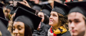 A UMBC graduate poses with True Grit after Winter Graduate Commencement 2018.