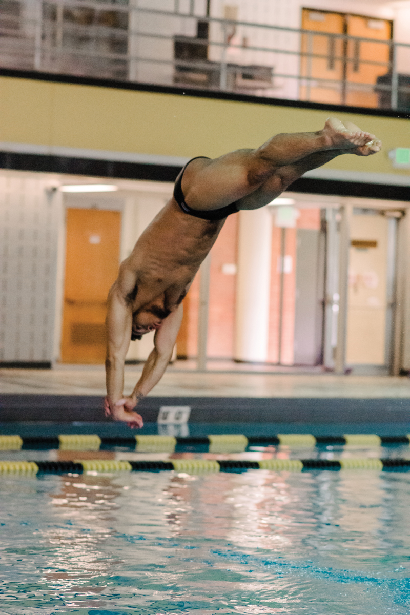 man assumes diving pose right above water