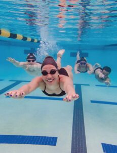 Haylee Committee hugs Tonia Papapertrou after the 100 freestyle. Photo by Colleen Humel.