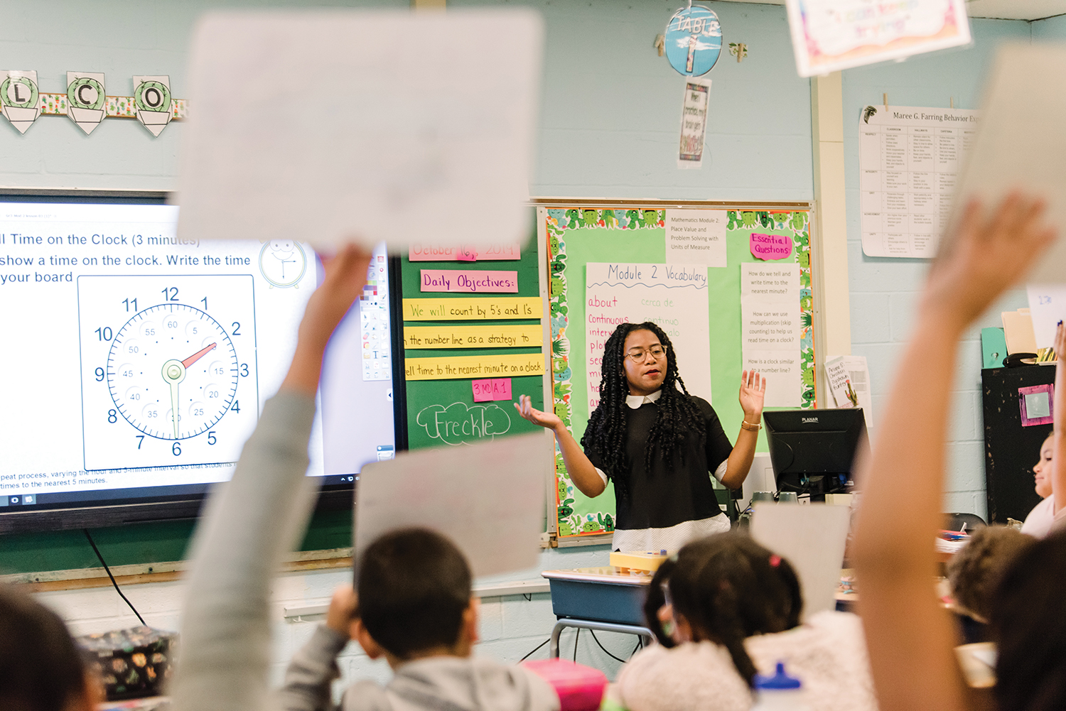 Lydia Coley teaches student time problems, students raising whiteboards with their answers written on them