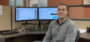 Chris Adams sitting in a chair in front of computer.