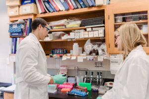 two people in lab coats in a biology lab
