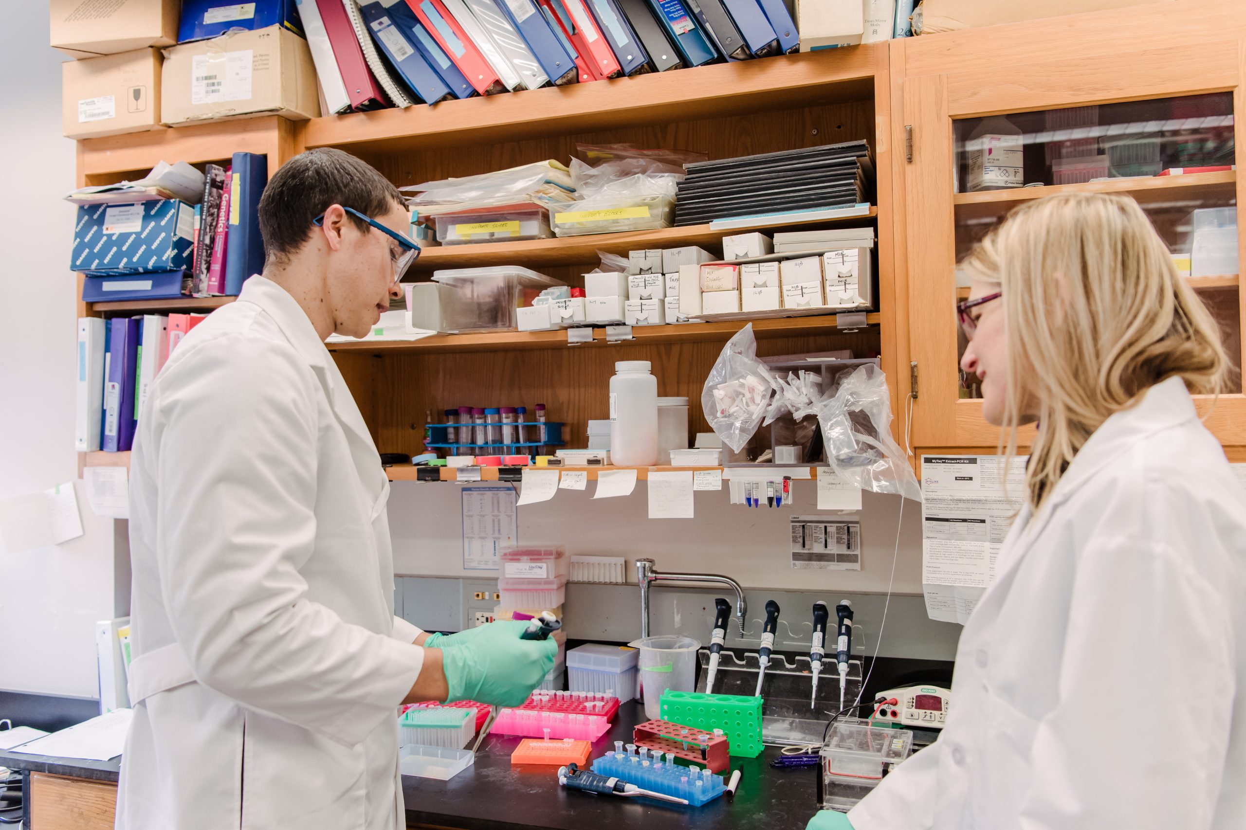 two people in lab coats in a biology lab