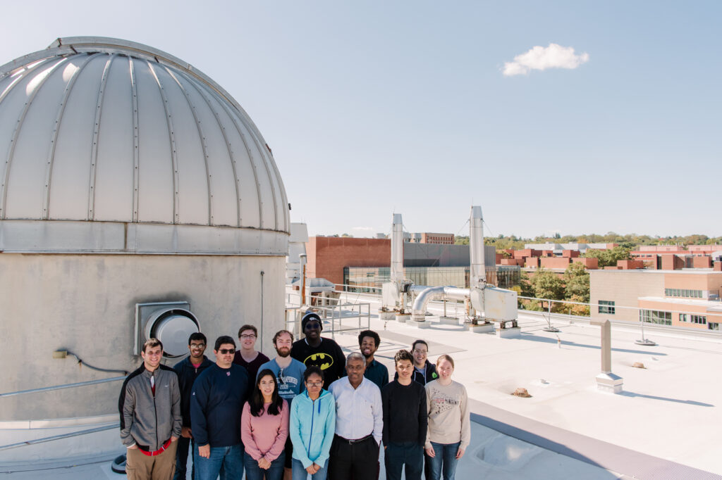Delgado with a group of physics students in 2019 next to the observatory on the roof of the physics building. 