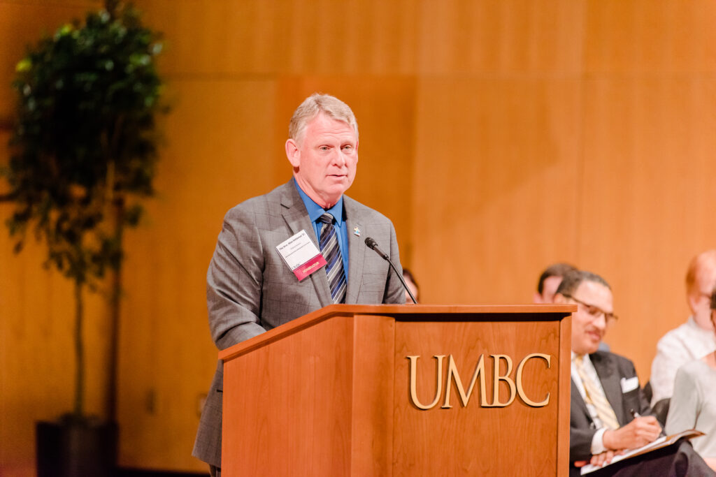 Alan Kittleman stands at a podium that says UMBC