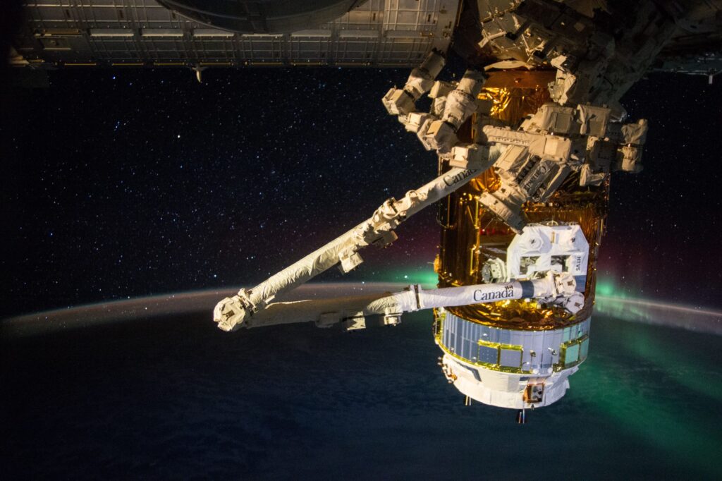 A large humanmade structure in space, with the edge of Earth visible in the background.
