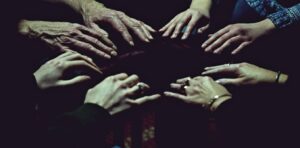 mediums hands lightly touch in a circle