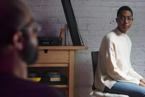 a person sitting in a chair looking at another person off-camera