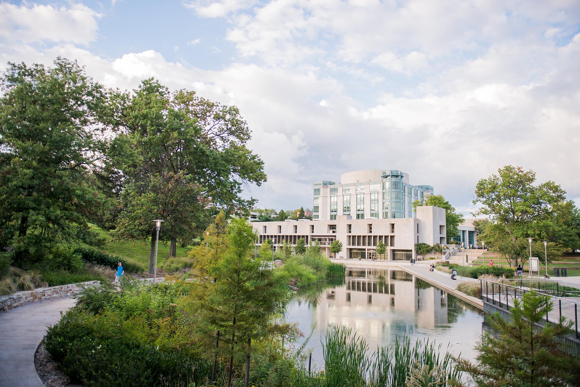 UMBC's campus in the fall, featuring the AOK Library and its reflection in a pond.