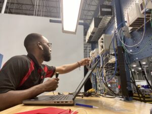 A man works with wires at a desk