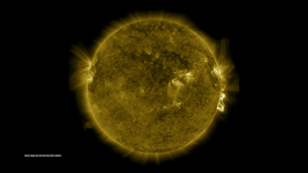 Dark yellow ball (the sun) with brighter yellow projections rising from the surface