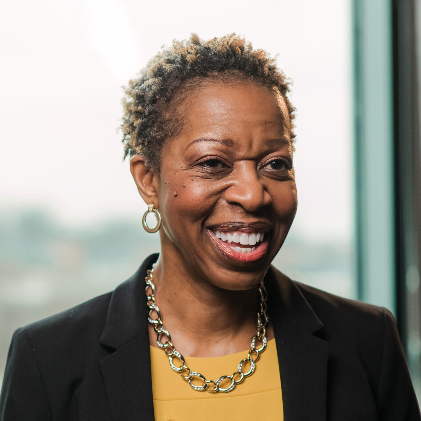 Portrait of Valerie Sheares Ashby, wearing a gold shirt with a black blazer to represent UMBC.