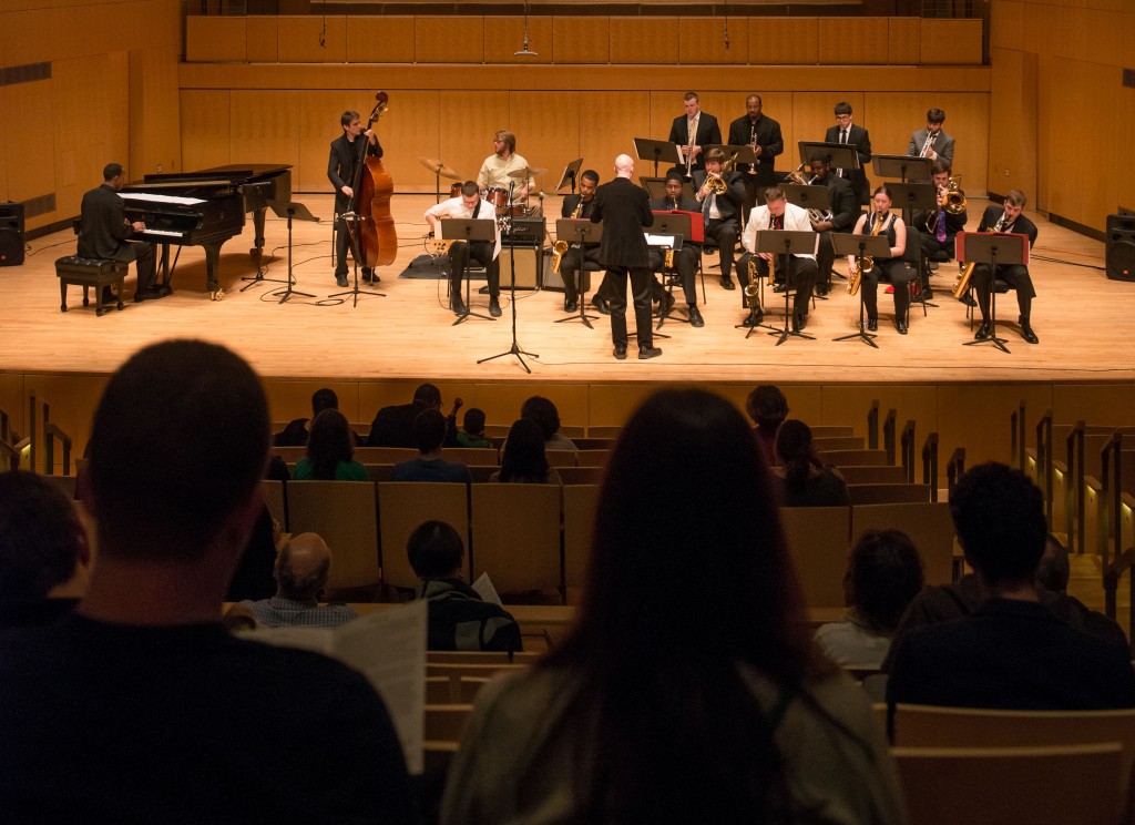 As viewed from the audience, a group of musicians perform on stage