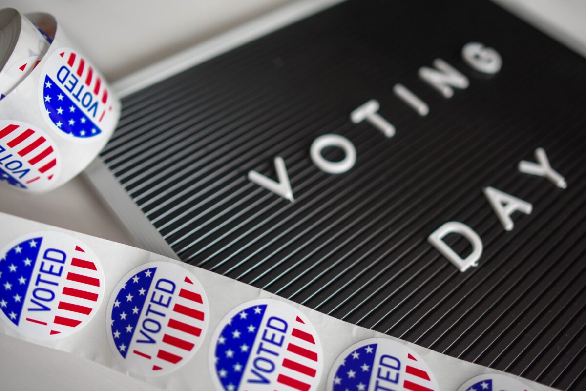 I voted stickers lay next to a board that says Voting Day