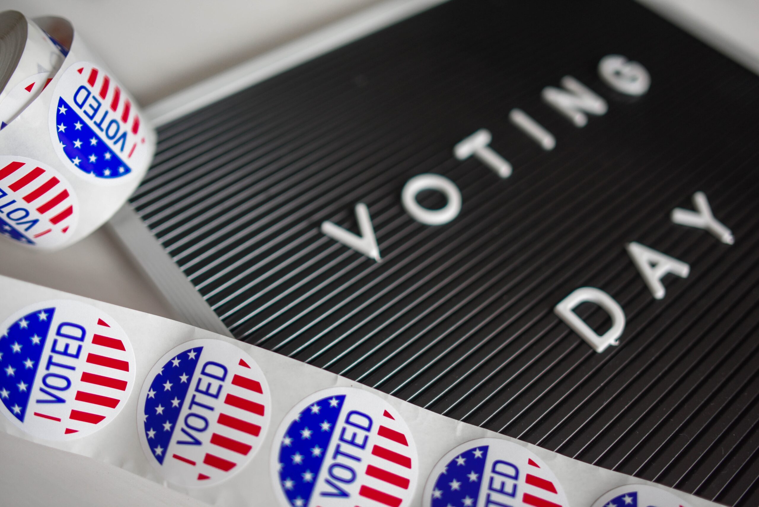 I voted stickers lay next to a board that says Voting Day