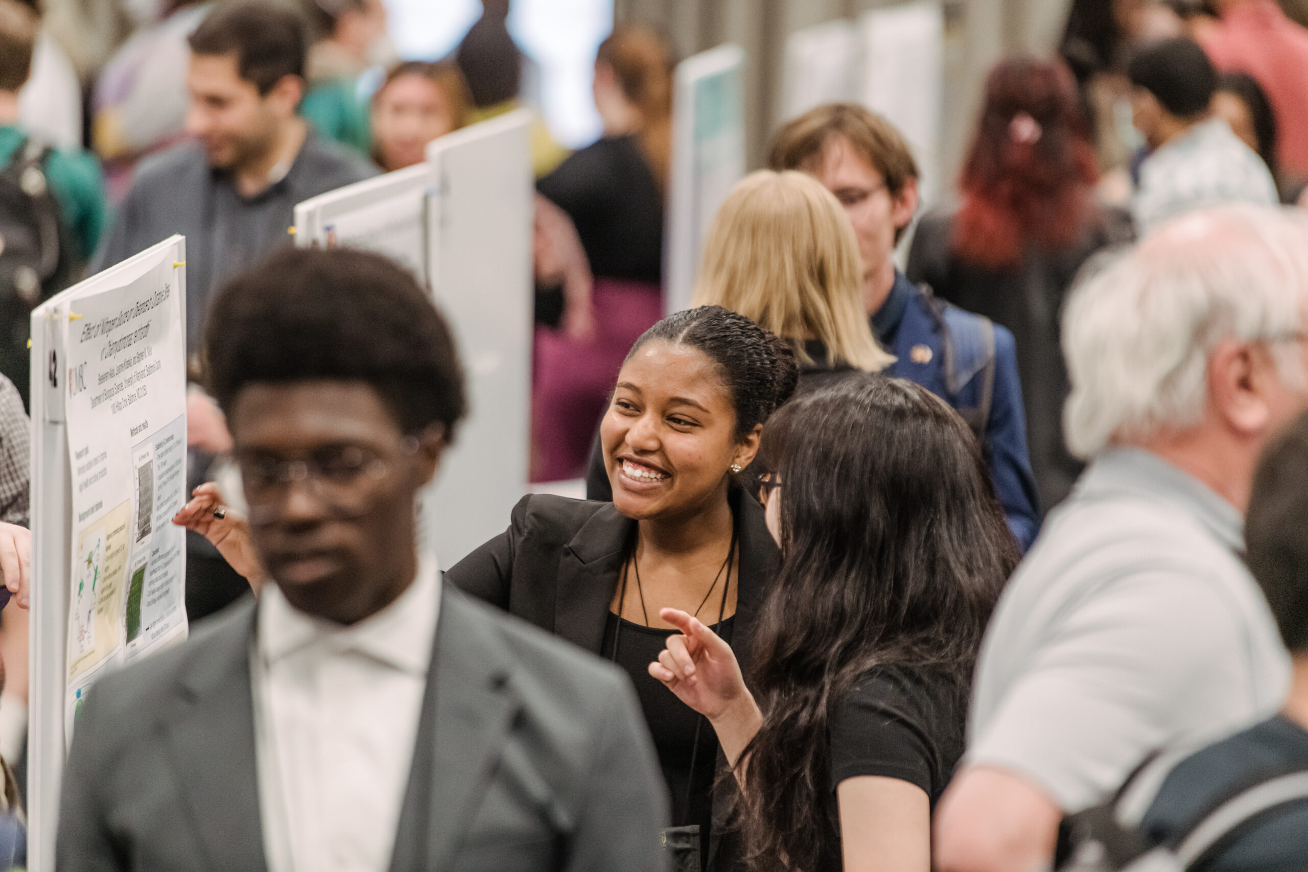 UMBC student smiling while presenting research at URCAD 2023. (Marlayna Demond '11/UMBC)
