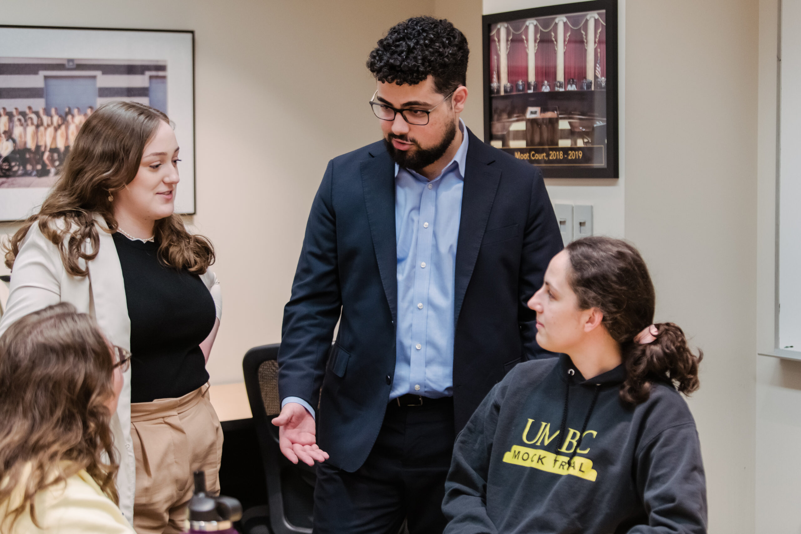 Three alumni coaches talk with the mock trial team