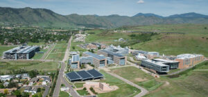 Set of modern buildings surrounded by green space, mountains in the background