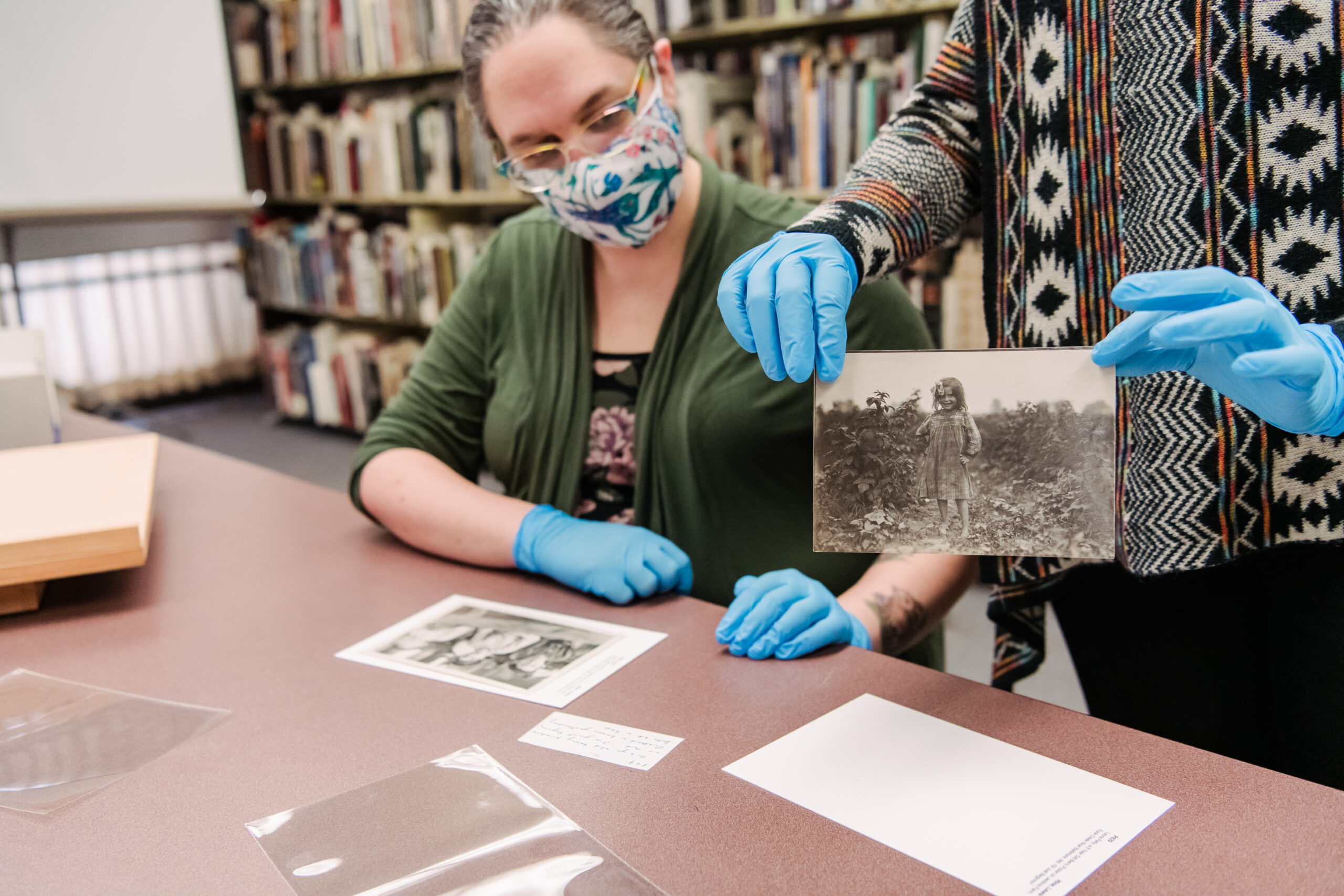 Meredith Power, left, and Susan Graham, right, handle the century-old photographs.