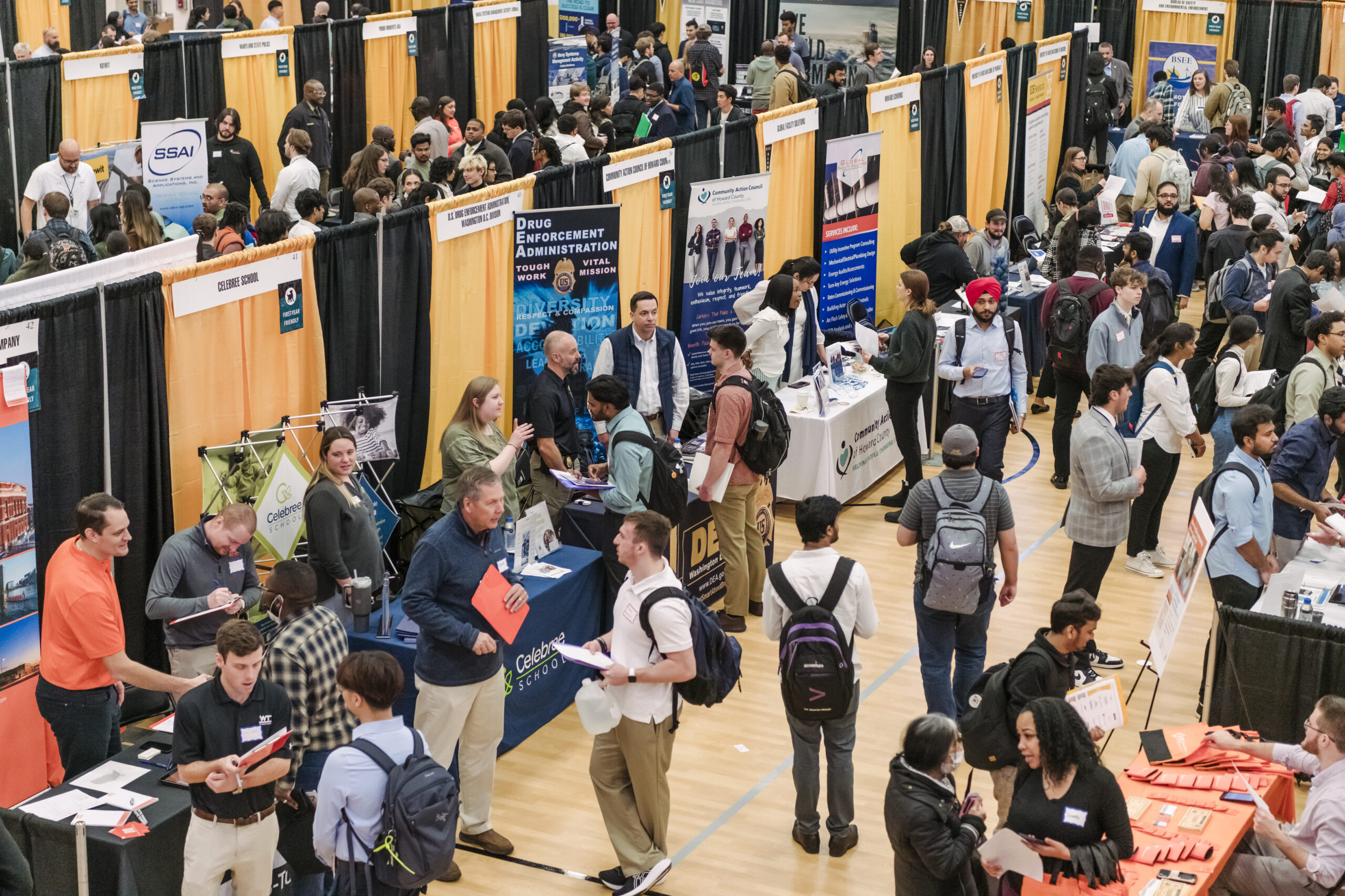 A gym filled with students and booths for a career fair