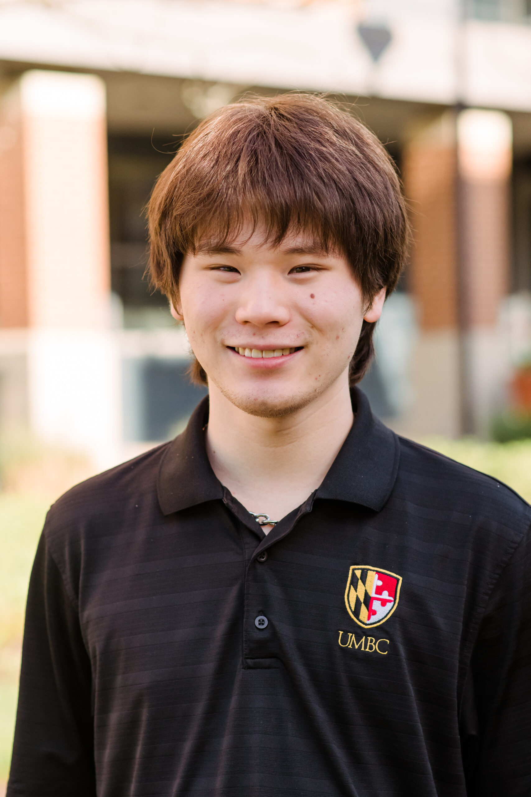 Headshot of Hyojin Choi wearing a black polo shirt with the UMBC logo.
