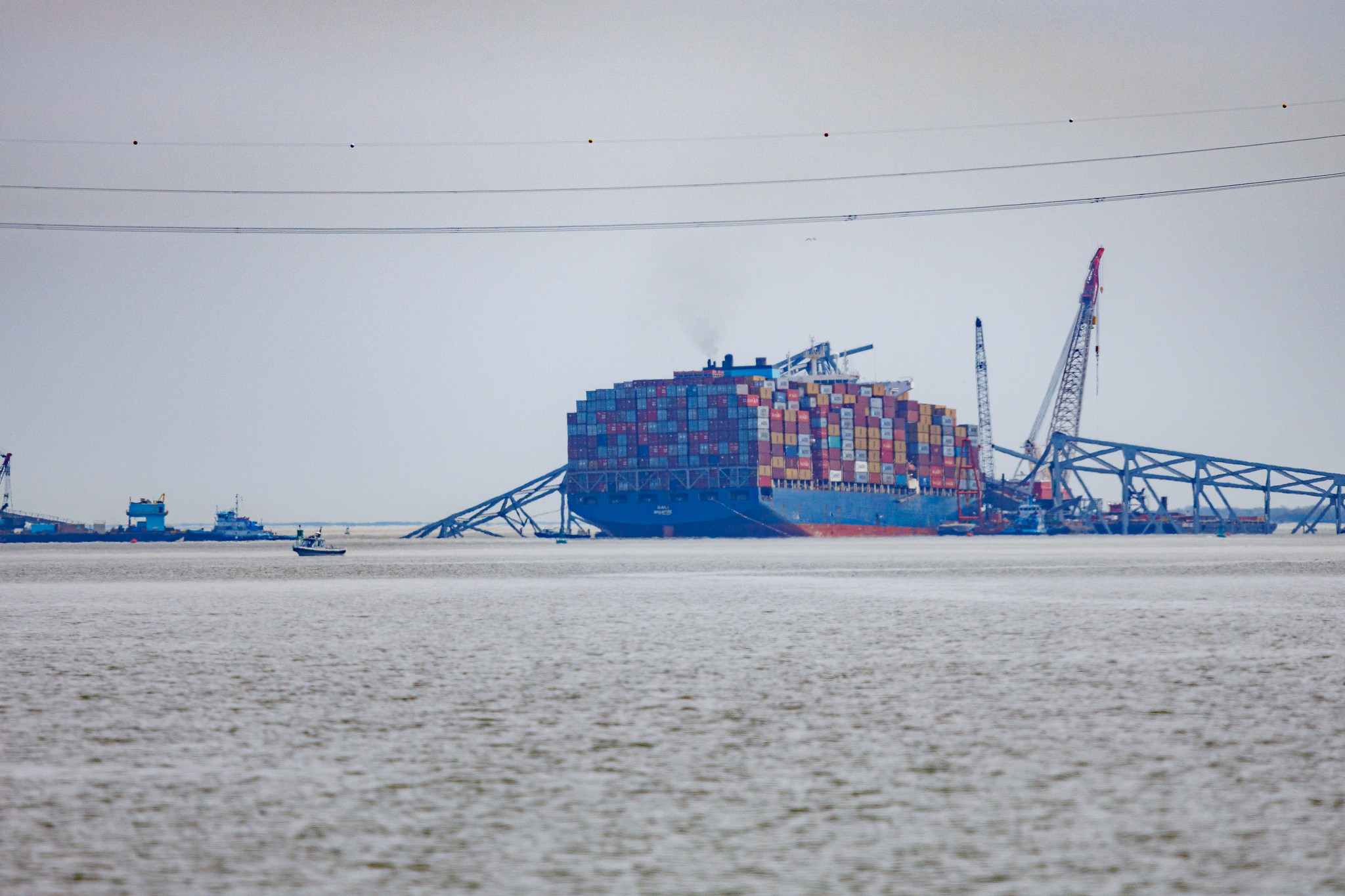 Cargo shipped in water with remains of the Francis Scott Key Bridge of top of the cargo ship