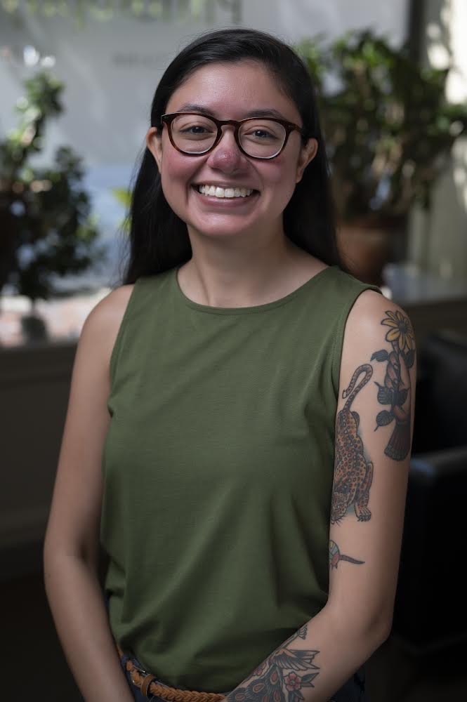 a woman in sleeveless shirt and glasses