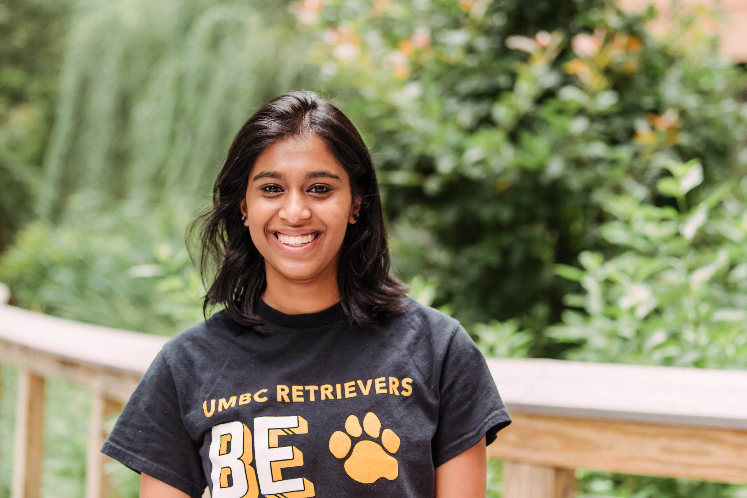 a woman translational life sciences student in a t-shirt poses on a bridge outside