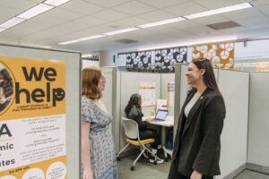 Two women academic advocates talk to each other in an office setting