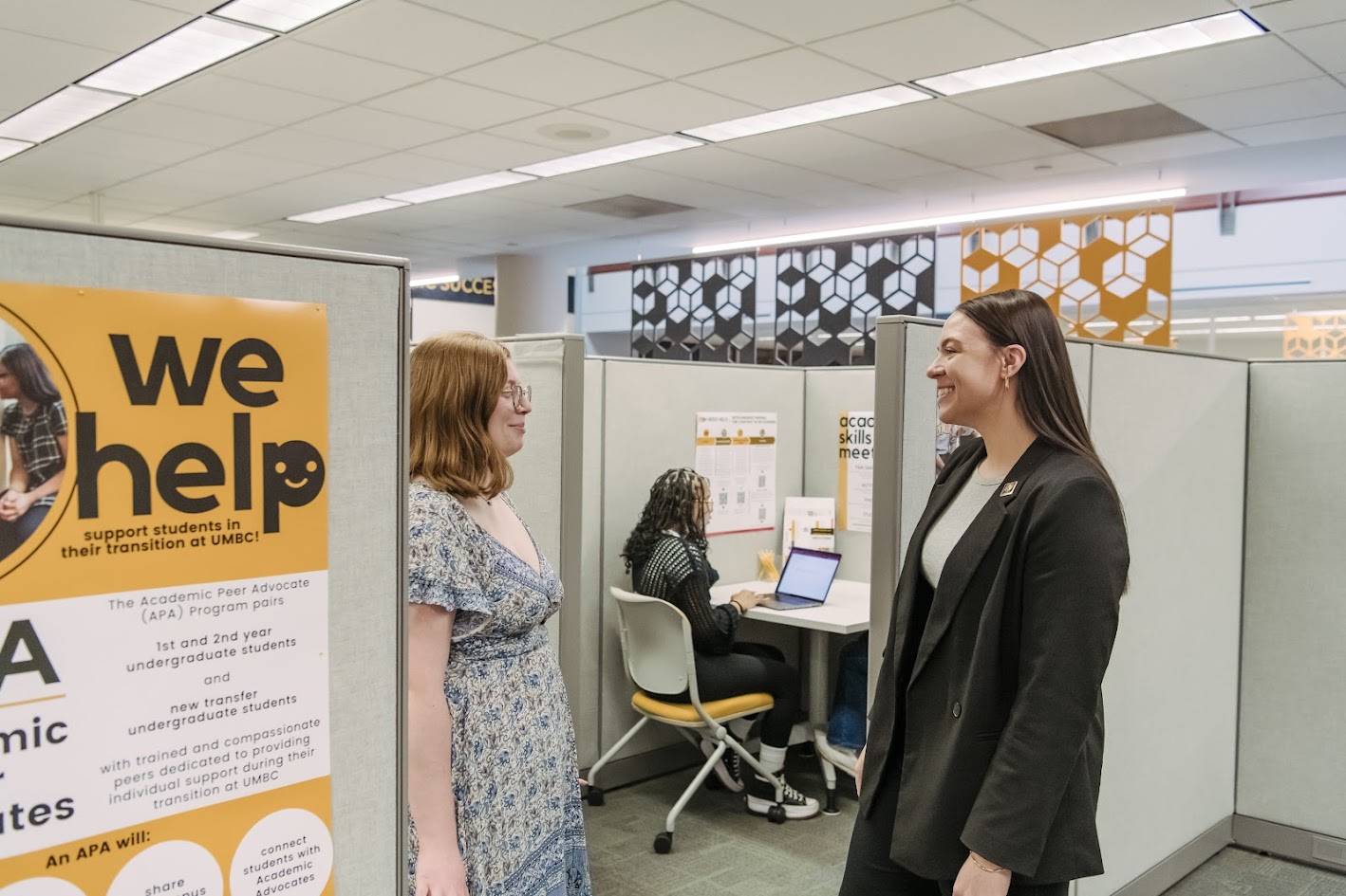 Two women academic advocates talk to each other in an office setting
