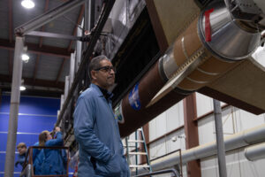 Planetary scientist Medhi Benna standing next to NASA's Dissipation sounding rocket.