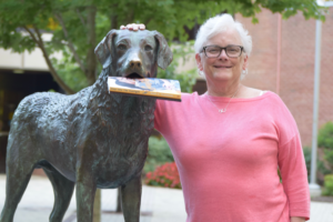 Mary K. Tilghman and True Grit with her books in the statue's mouth.