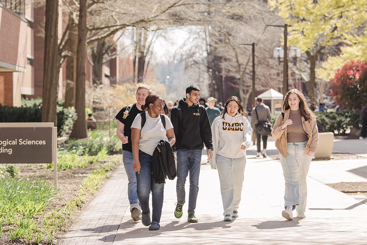 A group of UMBC students walking down academic row