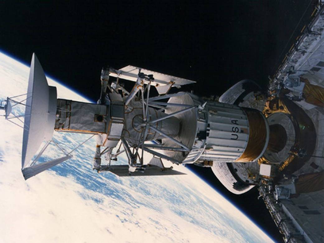 large spacecraft with "USA" on it flies above Earth before