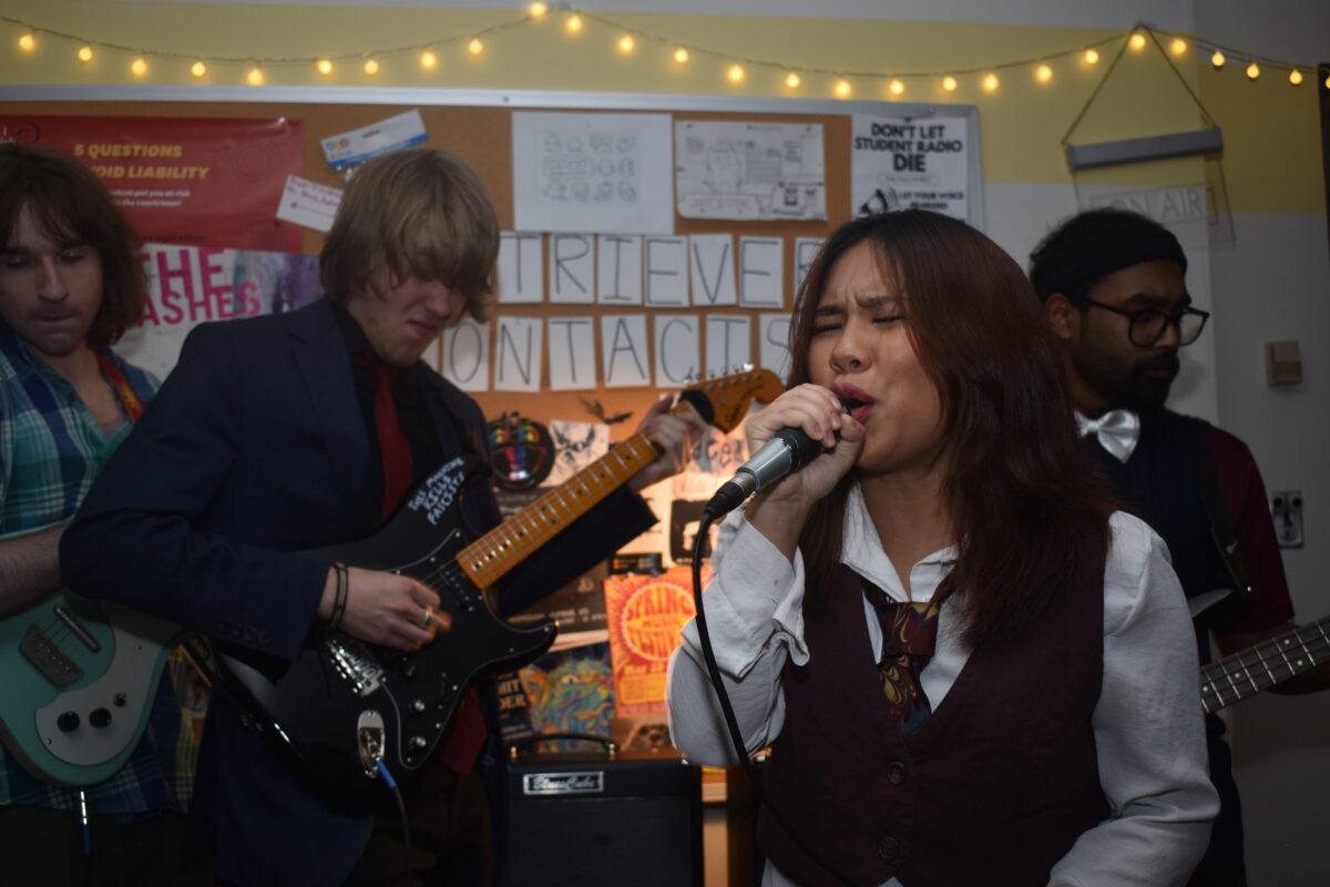 a woman sings into a microphone in a small musical venue