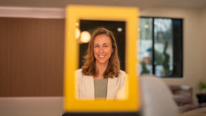 a woman with shoulder length hair is posing between a yellow border