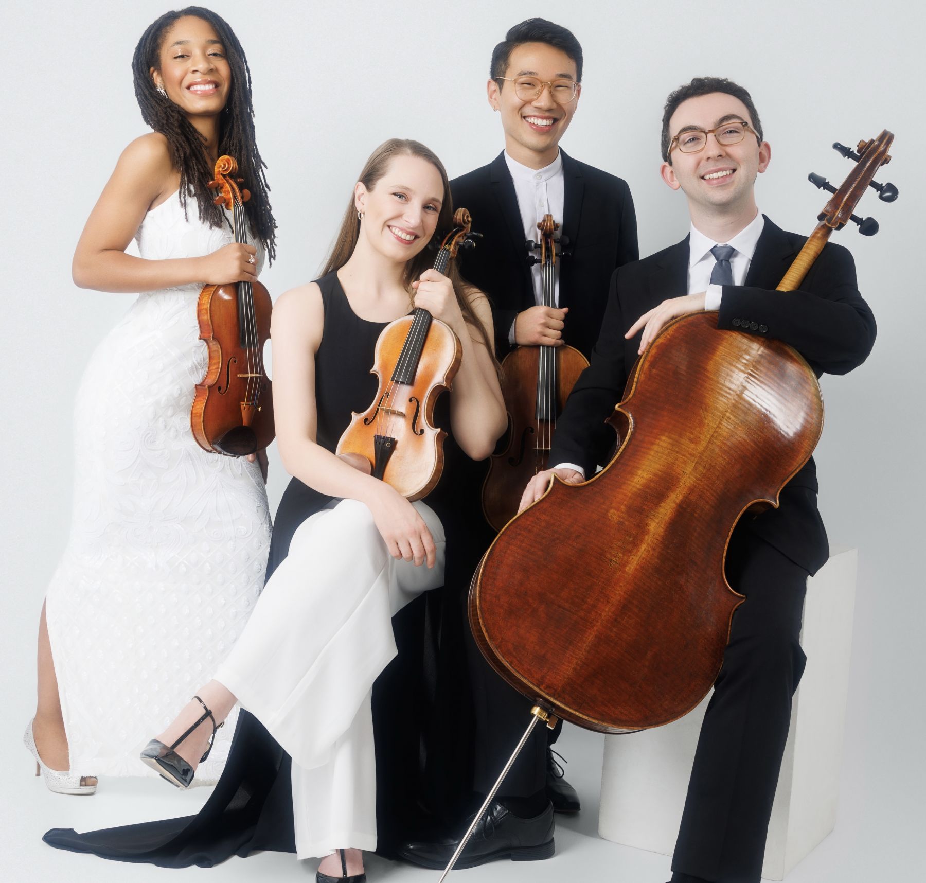 A string quartet poses with their instruments.