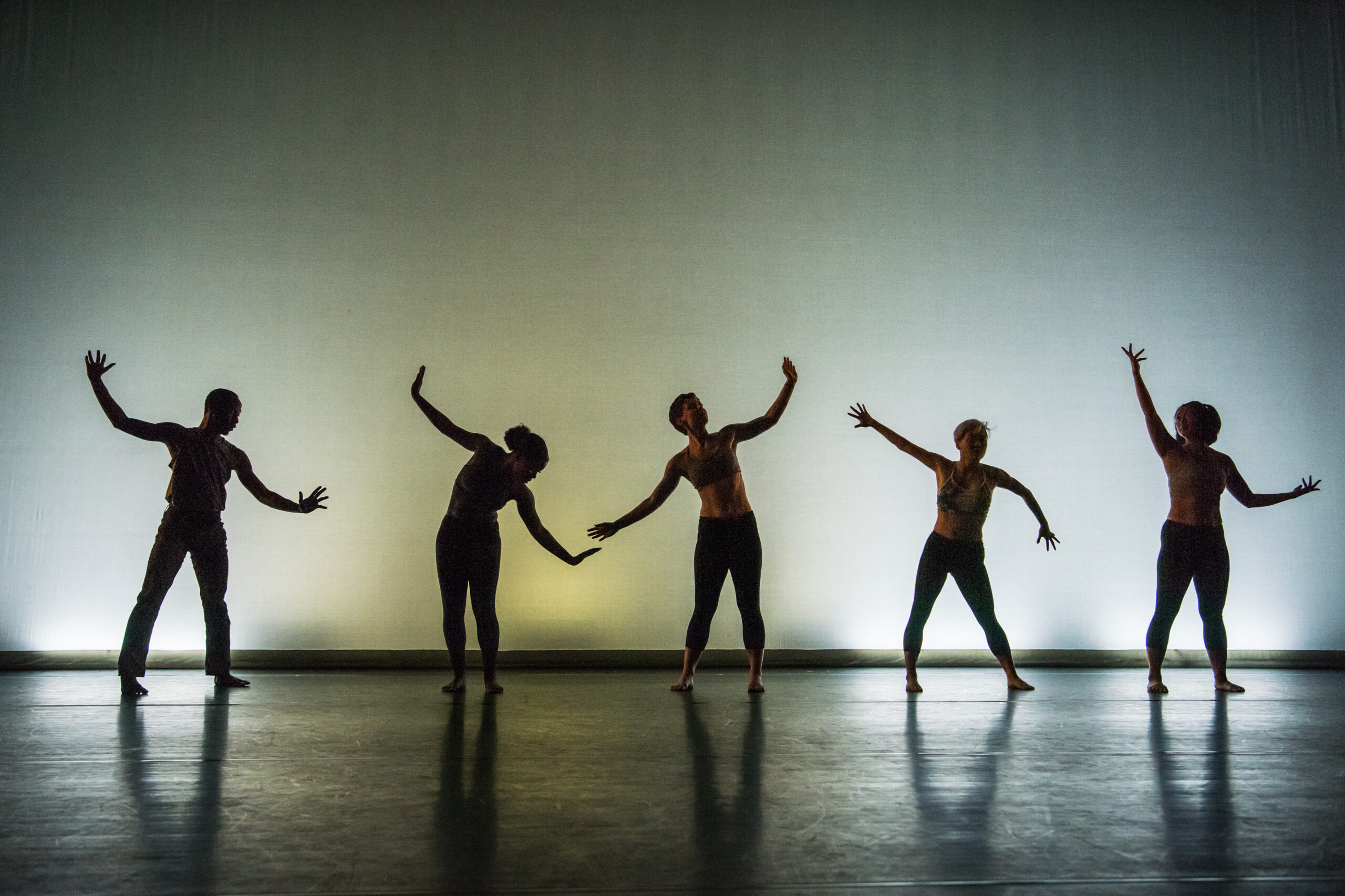 Five dancers perform on stage.