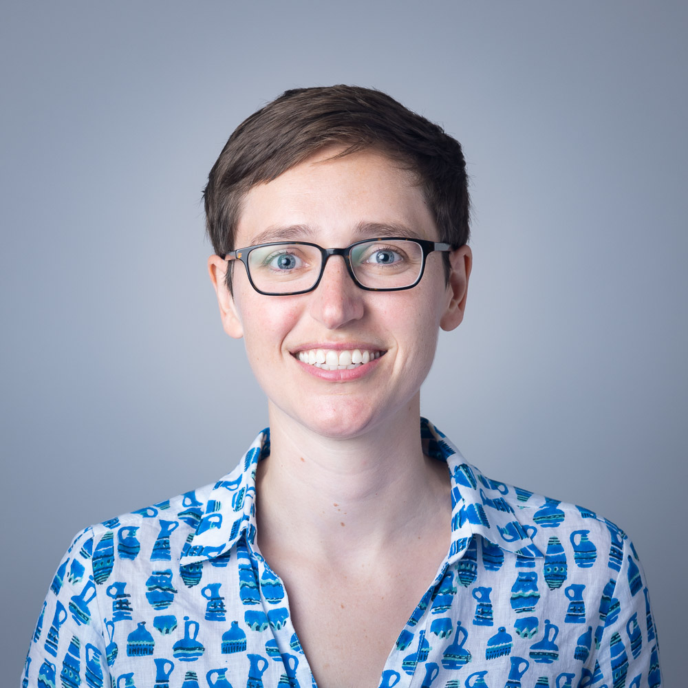 Debby Sneed, a white woman with short dark hair and glasses, wearing a blue shirt.