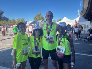Jackie King with group of three people in neon green shirts wearing medals and race bibs