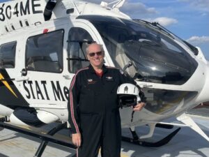 Pete Fitzpatrick, A pilot wearing a black uniform stands in front of a white medical emergency helicopter opioid