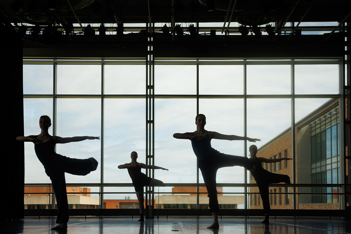 silhouette of dance students posing in unison
