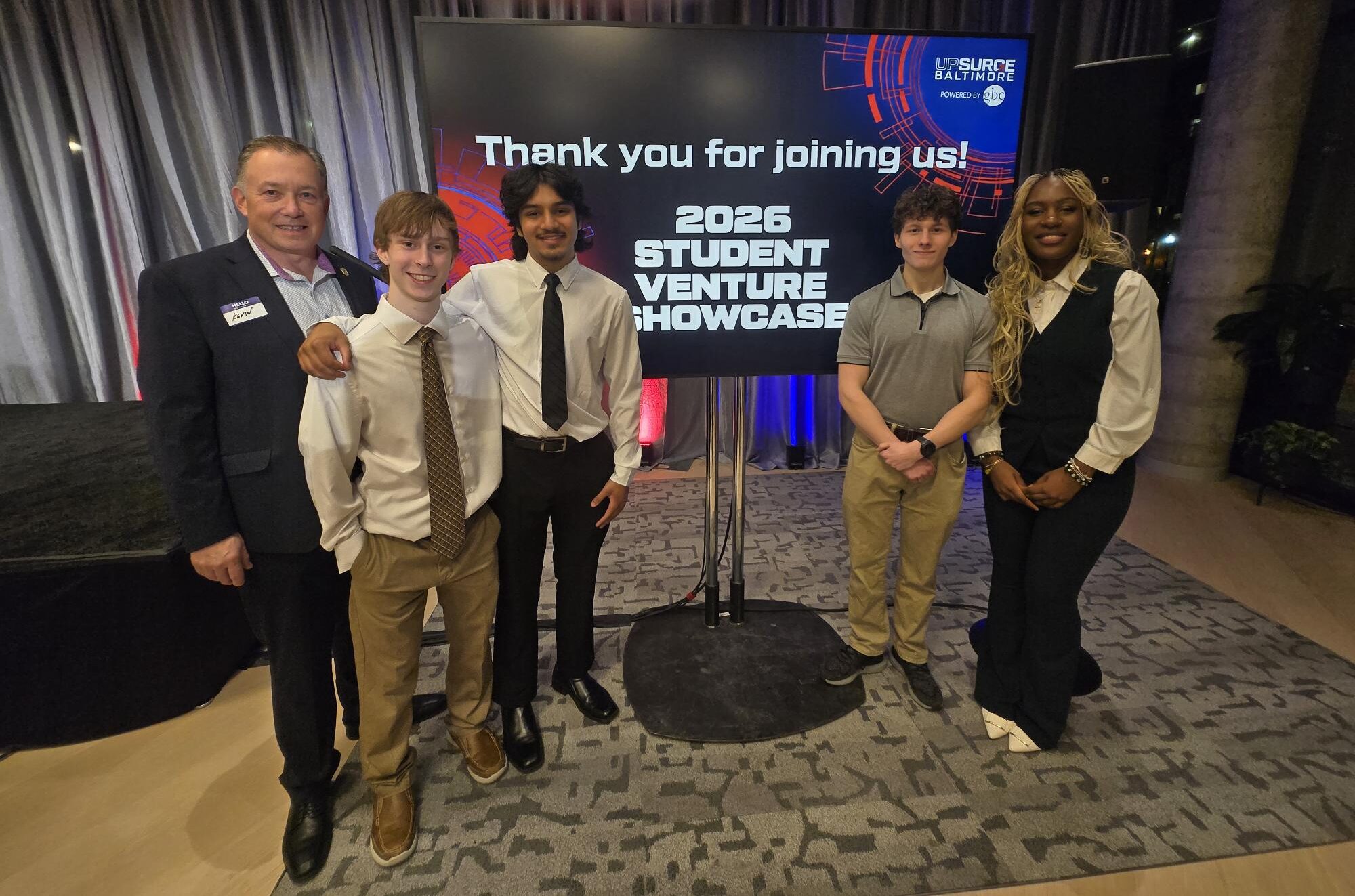 A group of five people stand in front of a sign reading "Thank you for joining us. 2026 Student Venture Showcase."