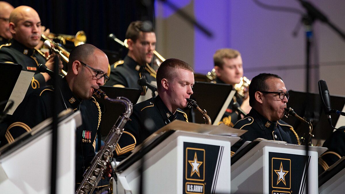 A group of musicians perform on brass instruments.