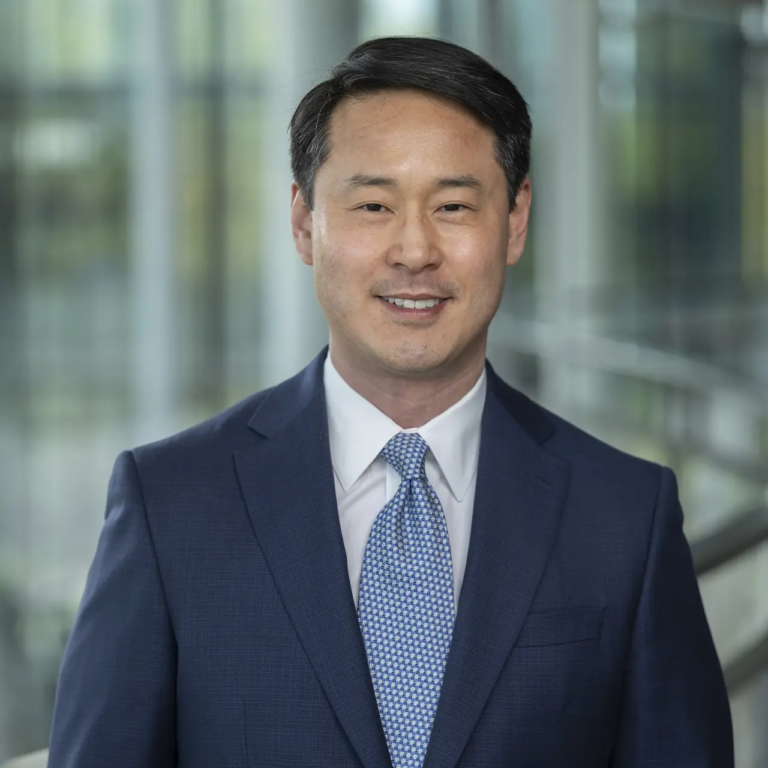 Headshot of a person wearing a suit and tie.